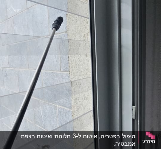 בדיקת איטום חלון והתזת מים סביב מסגרת החלון מחוץ לבית